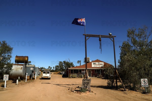 Rustic Mt Dare hotel in remote desert setting with Australian flag, zero