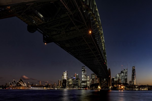Nighttime view of illuminated Sydney Harbour Bridge and Opera Houses, Sydney, New South Wales, Australia