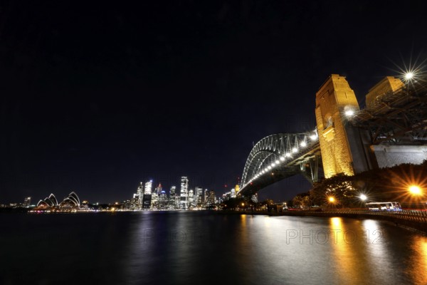 Sydney at night with the impressively illuminated bridge and opera house, Sydney, New South Wales, Australia
