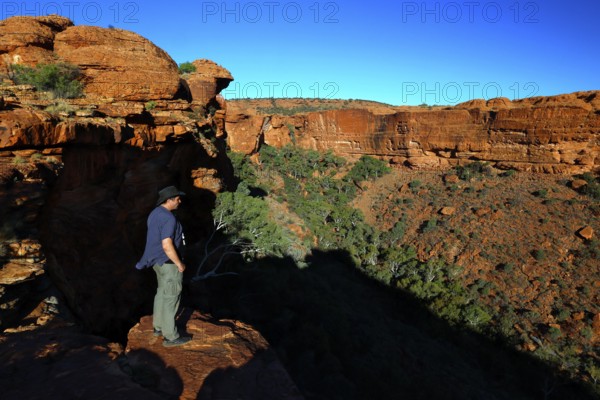 Person standing at the edge of Kings Canyon with deep views of the valley, Watarrka National Park, Northern Territory, Australia