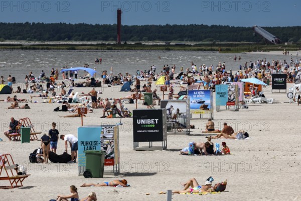 Busy sandy beach with lots of people and advertising signs under clear skies, Pärnu, Pärnu County, Estonia