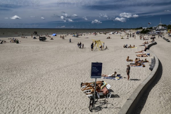 Long, extensive beach with sun beds and walkers under a blue sky, Pärnu, Pärnu County, Estonia
