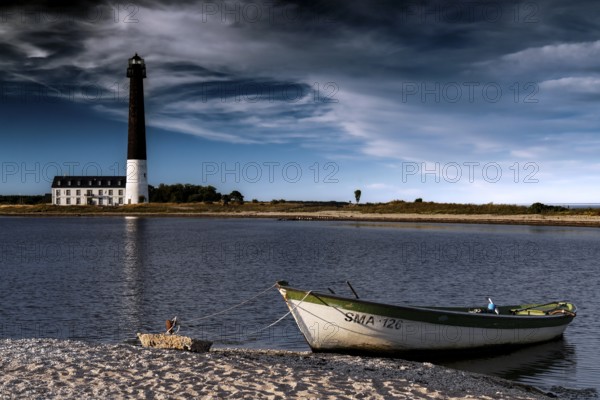 Lighthouse and boat on a quiet beach with dramatic clouds, Sääre, Saaremaa, Estonia