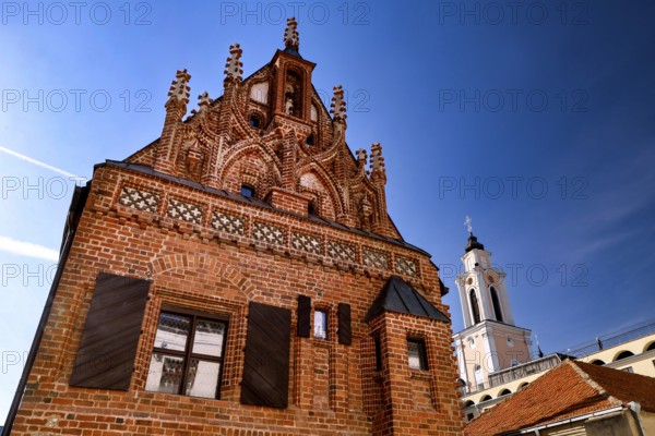 Gothic brick building with distinctive tiled roof and tower in the blue sky, Kaunas, Lithuania