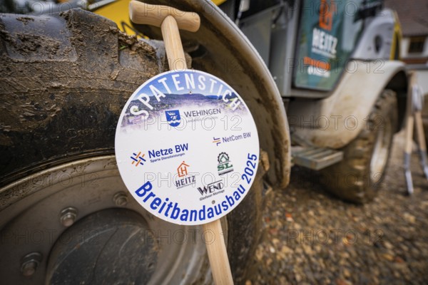 A sign announces broadband expansion, in the background a wheel loader on muddy ground, fiberglass groundbreaking, Dornstetten, Freudenstadt, Germany