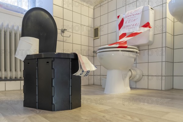 Symbolic picture blackout, extensive, prolonged power failure, in private environments, without electricity, the water supply also fails, toilet flush no longer works, emergency toilet, mobile toilet, camping toilet as an emergency replacement, disposal in bags