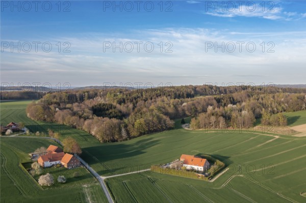 Small farms surrounded by green fields and forests from a bird's eye view, Osnabrücker Land, Wiehen Mountains, Lower Saxony, Germany