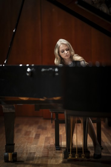 Young woman, pianist, with concentrated facial expression playing on a Steinway & Sons grand piano, Stuttgart, Baden-Württemberg, Germany