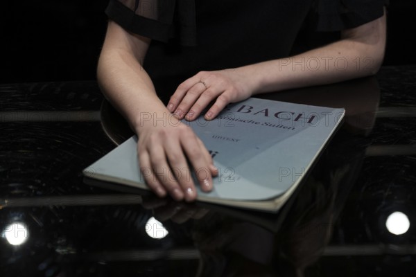 Hands of a young pianist rest on notes from Johann Sebastian Bach, Steinway & Sons-Flügel, Stuttgart, Baden-Württemberg, Germany