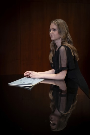 Young woman, pianist, in evening dress, with notes by Johann Sebastian Bach, supported on Steinway & Sons grand piano, Stuttgart, Baden-Württemberg, Germany