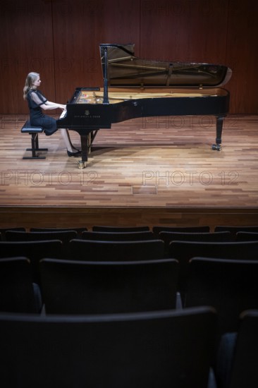 Young woman, pianist, in evening dress, in a concert hall, playing on a Steinway & Sons grand piano, Stuttgart, Baden-Württemberg, Germany