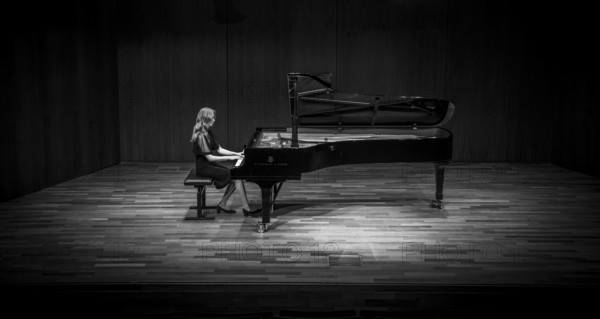 Young woman, pianist, in evening dress, in a concert hall, playing on a Steinway & Sons grand piano, black and white photo, Stuttgart, Baden-Württemberg, Germany