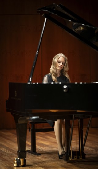 Young woman, pianist, with concentrated facial expression in a concert hall playing a Steinway & Sons grand piano, Stuttgart, Baden-Württemberg, Germany