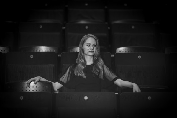 Young woman, pianist, in evening dress, sitting on chair in audience area, Stuttgart, Baden-Württemberg, black and white photo, Germany