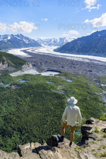 Young man enjoying the view, view of impressive mountain landscape with Matanuska glacier and glaciated mountain peaks, Lion's Head, Chugach Mountains, Alaska, USA