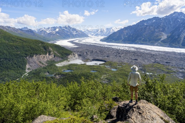 Young man enjoying the view of impressive mountain landscape with the Matanuska Glacier tongue, Lion's Head, Chugach Mountains, Alaska, USA