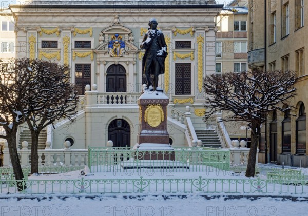 Baroque Old Trade Exchange, bronze statue of the Goethe monument by Carl Seffner depicting Johann Wolfgang von Goethe, at Naschmarkt in winter with snow, Leipzig, Saxony, Germany