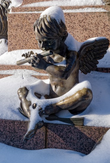 An angel playing the flute, figure at the Felix Mendessohn Bartholdy monument in winter with snow, Leipzig, Saxony, Germany