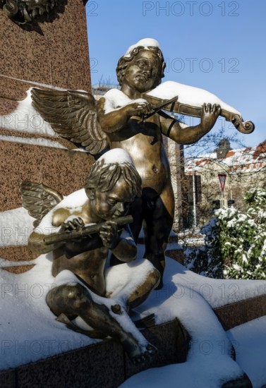 Two angels playing music, figure at the Felix Mendessohn Bartholdy monument in winter with snow, violin and flute, Leipzig, Saxony, Germany