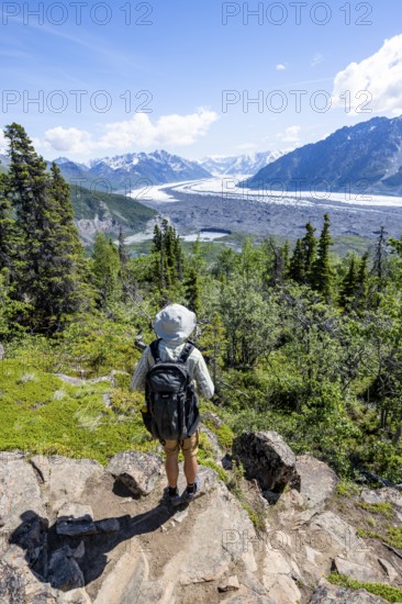 Young man enjoying the view, view of impressive mountain landscape with Matanuska glacier and glaciated mountain peaks, Lion's Head, Chugach Mountains, Alaska, USA