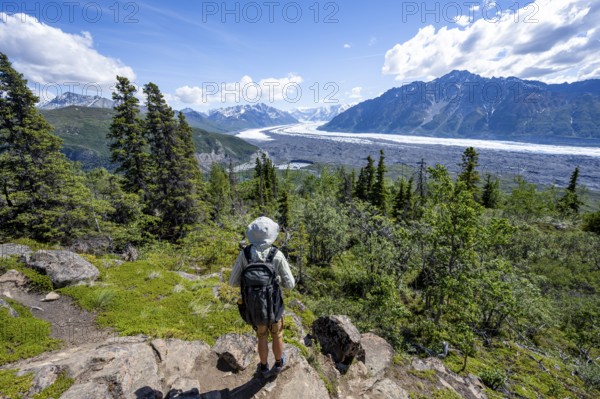 Young man enjoying the view, view of impressive mountain landscape with Matanuska glacier and glaciated mountain peaks, Lion's Head, Chugach Mountains, Alaska, USA
