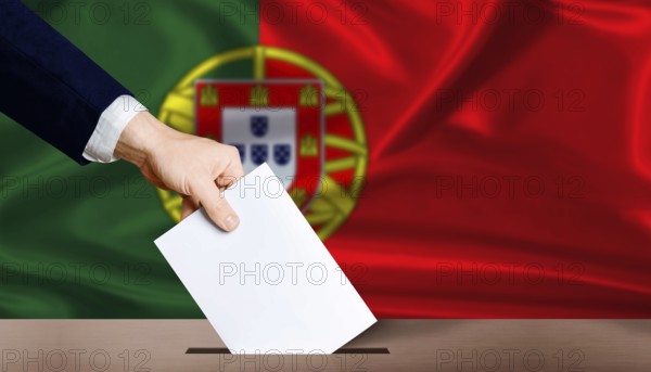 Hand placing a ballot in ballot box with the Portuguese flag in the background. Portugal presidential vote 2026