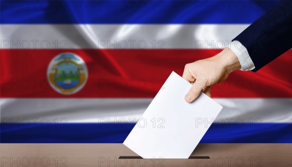 Hand placing a ballot in ballot box with the Costa Rican flag in the background. Costa Rica presidential vote 2026