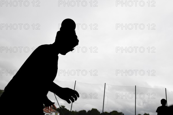 Silhouette of a person against cloudy sky, athletic posture, sports and fun Olympics Sportfest School, Lower Saxony, Germany