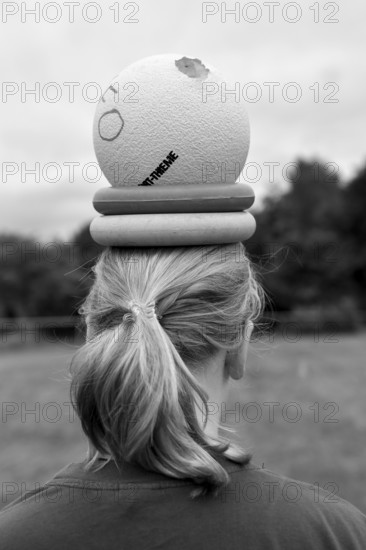 Person with ball and wrestling on head, environment in nature, sports and fun Olympics sports festival school, Lower Saxony, Germany