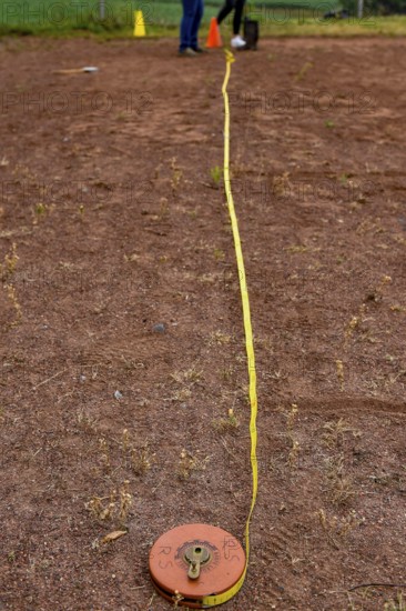A tape measure and a sports disc lie on an ash track, marking a point in competition, Lower Saxony, Germany