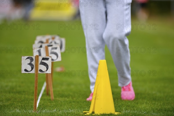 Person on grass with yellow hat and numbers, sporting activity, sports and fun Olympics Sportfest School, Lower Saxony, Germany