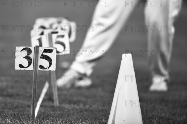 Black and white image of a person on grass with cones and numbers, Sports and Fun Olympics Sports Festival School, Lower Saxony, Germany