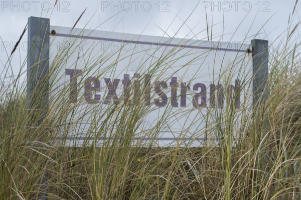 Beach oats in front of the textile beach sign, Baltic resort Göhren, Baltic Sea, Rügen island, Mecklenburg-Western Pomerania, Germany