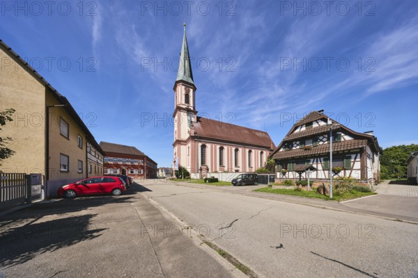 St. James church, church tower, half-timbered house, residential building, commercial building, street, parking boxes with cars, trees, meadow, blue sky, cirrus clouds, Kirchstraße, Grafenhausen district, Kappel-Grafenhausen, Black Forest, Ortenaukreis, Baden-Württemberg, Germany