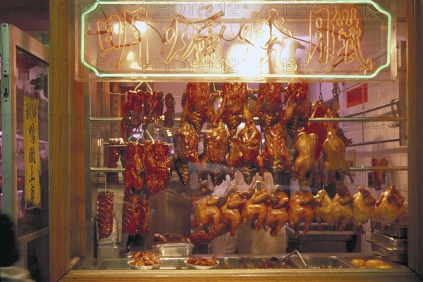 Ready to cook poultry in a shop window in Chinatown, New York City, USA