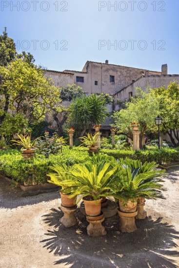 Arab baths garden in Palma de Mallorca with flowers and lush green plants by a garden path, Palma de Mallorca, Mallorca, Spain