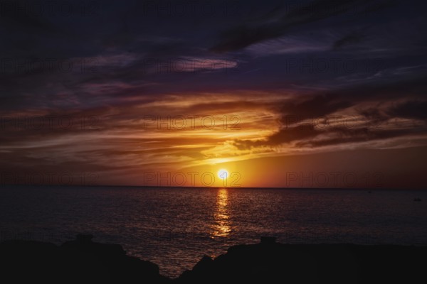 Impressive sunset over the sea with colorful skies and water reflections, Playa Blanca Lanzarote