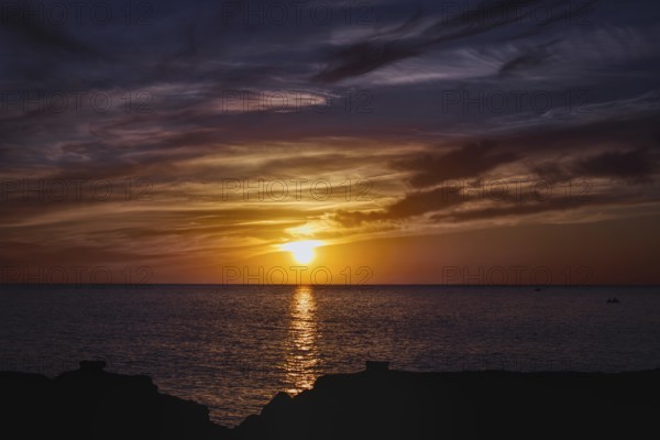Colourful sunset over the sea with reflective, dramatic cloud formations, Playa Blanca Lanzarote