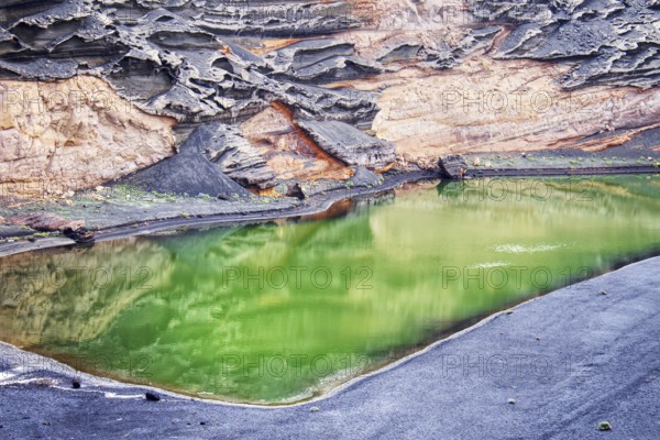 Green volcanic lake (Lago Verde) surrounded by dramatic rock formations and landscape reflections, El Golfo Lanzarote
