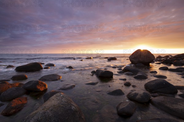 Rocky bay under a dramatic glowing sky at the coast. unset, Vigrestad, Rogaland, Norway