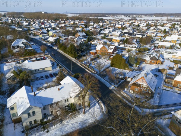 Inhabited area in snow with several houses along a road on a clear day, aerial view, Oelsburg, Ilsede, Peine district, Lower Saxony, Germany
