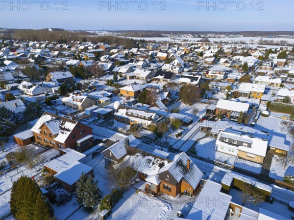 Residential district in winter under clear sky, with snow-covered roofs and roads, aerial view, Oelsburg, Ilsede, Peine district, Lower Saxony, Germany