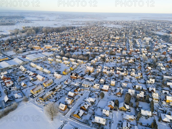Snowy village landscape in evening light with numerous houses and roads, aerial view, Oelsburg, Ilsede, Peine district, Lower Saxony, Germany