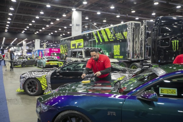 Detroit, Michigan USA - 14 January 2026 - A worker polishes a vehicle being displayed at the Detroit Auto Show