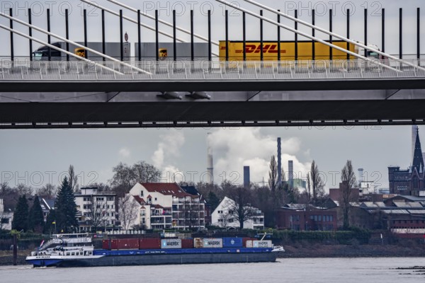 Shipping traffic on the Rhine near Duisburg-Homberg, new A40 motorway, Neuenkamp Rhine bridge, first construction phase, Friedrich-Ebert bridge between Homberg and Ruhrort in the back, industrial setting of the ThyssenKrupp steel plant, DHL and UPS trucks, North Rhine-Westphalia, Germany
