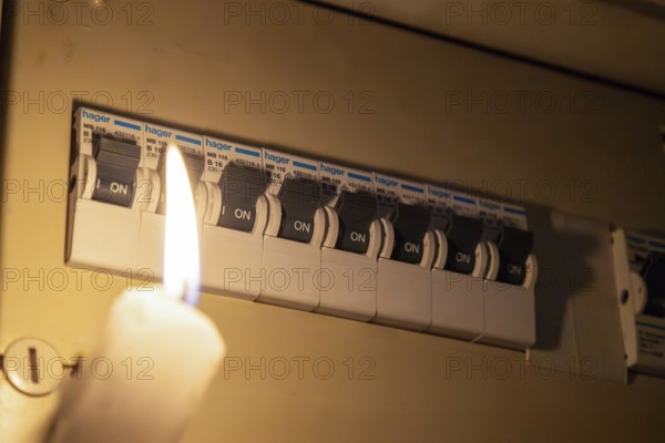 Blackout symbol image: Illuminating a distribution box with a candle