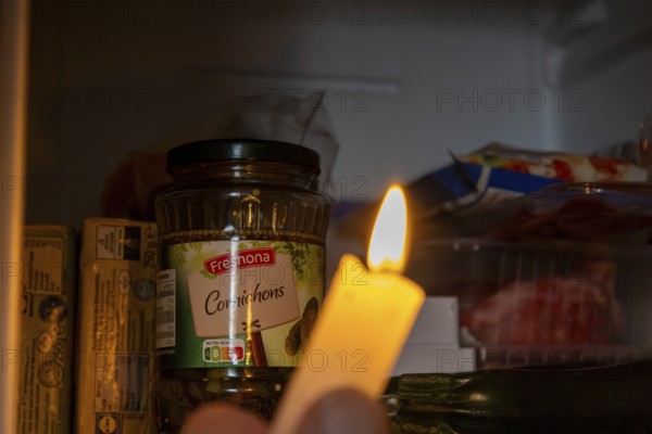 Blackout icon: Illuminating a dark refrigerator with a candle