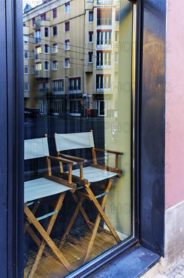 Two wooden chairs stand behind a shop window, Berlin, Germany