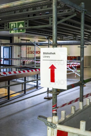 Technical University in Berlin, provisional information sheets and signs at an indoor construction site show the way towards the library, Berlin, Germany