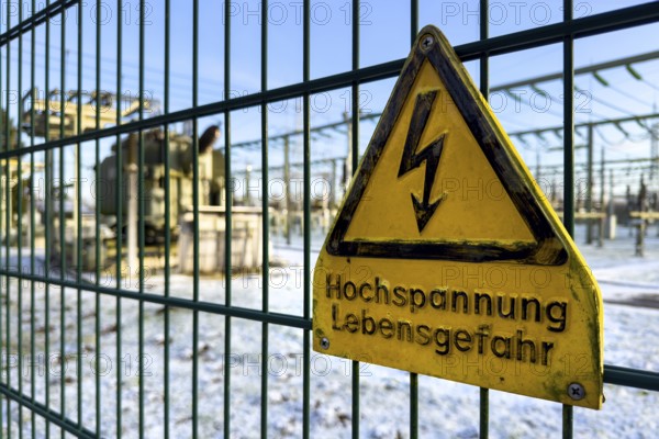 Recording of snow in winter warning sign warning high voltage danger to life on fence from behind substation substation substation substation part of electrical supply network with transformer generator in the background high-voltage lines high-voltage pole for secure energy supply Power supply, Germany